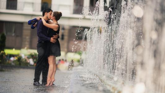 女孩和男朋友在喷泉附近亲吻，恋爱中的情侣